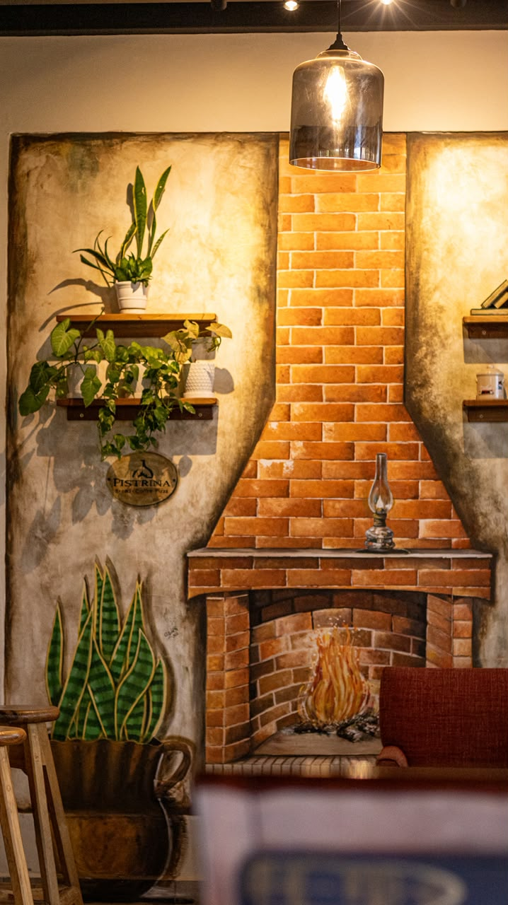 Interior de Pistrina con chimenea de ladrillo, plantas y lámpara colgante